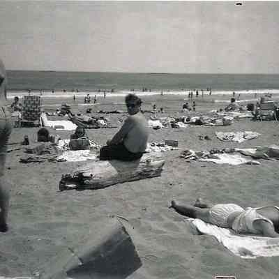 A B/W photograph of people on a beach.