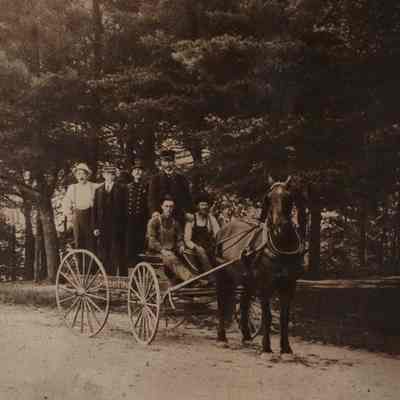 A photo of six men in a wagon.