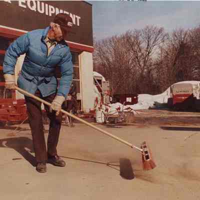 A photo view of a workman sweeping. 2/25/1987.