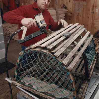 A photo view of a man repairing lobster traps. 3/21/1989.