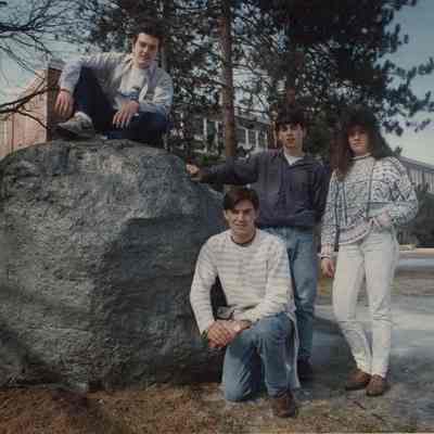A photo view of 4 people around a big rock. 3/5/1992.