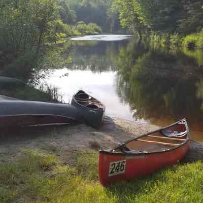 Robinson's Private Beach: Canoes and watercraft line the shore of the Dennys River at Robinson's private beach.