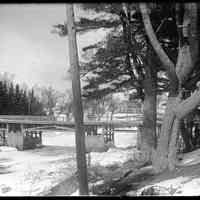          Lower Bridge in Winter, Dennys River, Maine; Winter ice necessitated the careful protection of the pilings supporting the Lower Bridge, in this view from Edmunds, looking across the ice choked tidal estuary of the Dennys River, in this photograph by John P. Sheahan, c. 1890.  The Lincoln House in Dennysville is visible through the trees.
   