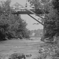          Falls Bridge on the Dennys River.; Houses and barn on the Milwaukee Road in Dennysville, seen under the Falls Bridge over the Dennys River, in a photograph taken by John P. Sheahan of Edmunds c. 1885.
   