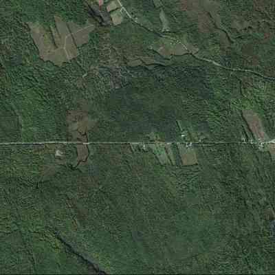 Cooper, Maine, on Google Earth: Satellite view of the sites of the former Cooper Saw Mill, Post Office at the sharp corner on the left, to the Evergreen Cemetery on the right in this Google Earth image accessed on 08-12-2023.