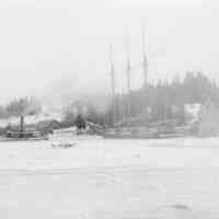          Schooner Jennie French caught in the ice on the Dennys River; Peter E. Vose's wharf is seen behind the steam tug 