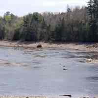          Rock Peter in the Dennys River; Rock Peter stands sentinel-like on the Edmund side of the Dennys River in eastern Maine, with the remains of T.W. Allan's wharf visible on the right.  As part  of the bedrock, Rock Peter served as the origan or starting point for all of the early surveys of the local area.
   