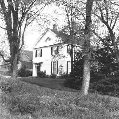 T.W. Allan House, Icehouse, and Barn in 1980: The end of T.W. Allan's house, with the icehouse built into the hillside and large barn visible above.  Photograph taken by Frank Beard for the Maine Historic Preservation Commission, documenting the nomination of the Dennysville village as a National Historic District.