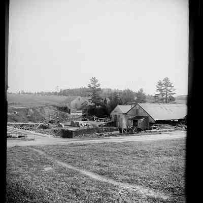 Lincoln Mill buildings on the Dennys River, c. 1885: Machine shop (left) and mill buildings adjacent to the Upper Bridge over the Dennys river in this photograph taken by John P. Sheahan of Edmunds, Maine.