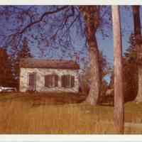          Azor Baker House on King Street, Dennysville in the 20th century.; Laundry is drying on the line in this picture from around the 1950's.  Note the gable end of a garage or barn across the drive.
   