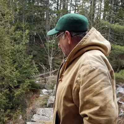 Robert "Bobby" Bell stands on the old stone dam on Crane Brook where his family once operated a saw, lath and shingle mill.