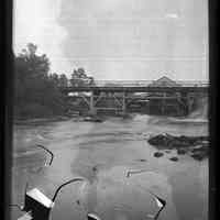          Upper Bridge of the Dennys River, by John P. Sheahan, c. 1885; Photographic image of the Upper (upstream) Bridge below the Lincoln mills on the Dennys River.  The sluice is on the right-hand or Dennysville side of the river, with the State Seal pines on the Edmunds shore to the left.  The photographer, Dr. John Parris Sheahan of Edmunds, has contrived to photograph his horse and buggy on the bridge of the left of the lath and shingle mill.  This bridge is documented by Rebecca Hobart in her town history as being constructed by agreement of both communities in 1836.
   