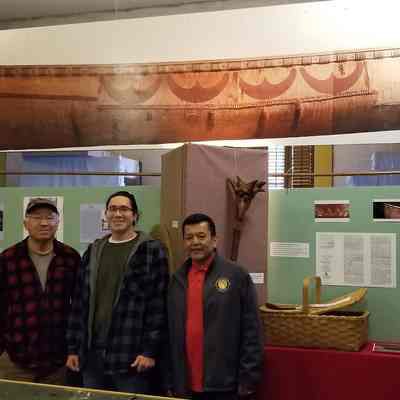 Tribal members with Passamaquoddy Canoe: Three members of the tribe pose with a life size photographic reproduction of a Passamaquoddy birchbark canoe at an exhibition at the Academy-Vestry Museum in Dennysville, Maine, during the summer of 2022.   They are, left to right: Donald Soctomah, Tribal Historic Preservation Officer, his grandson Donald Soctomah, and tribal linguist Dwayne Tomah.