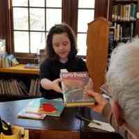          Front desk at the Lincoln Memorial Library; A young patron signs out a Harry Potter book at the Library in Dennysville.
   