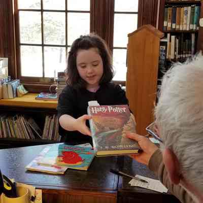 Front desk at the Lincoln Memorial Library: A young patron signs out a Harry Potter book at the Library in Dennysville.