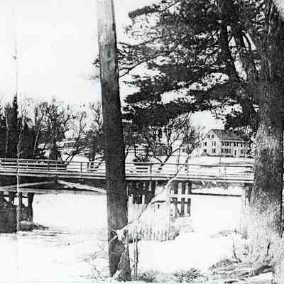 The Lower Bridge viewed from the Edmunds side with the Lincoln House in the background.: The wooden cribbing protected the rubble stone piers from scouring by the ice that rose and fell with the tide twice daily.  Photograph by Dr. John P. Sheahan of Edmunds.
