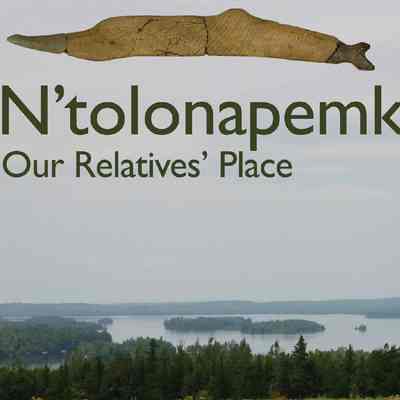 N'tolonapemk, Meddybemps lake.: View of Meddybemps Lake, site of the ancestral Passamaquoddy village of N'tolonapemk, occupied 9000 years before the present, B.P.  The stone artifact above the picture was found in three sections during the archeological excavation of the site in 2000, and may be a tool, a representation of a fish, or have some other function.