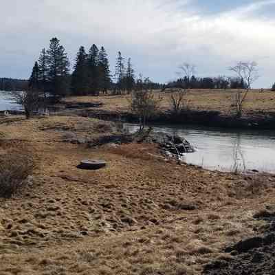 Tidal gore at the site of the Robert Bell's tide mill in Edmunds, Maine, with contemporary family dwelling overlooking the site of his original house beside the stream.