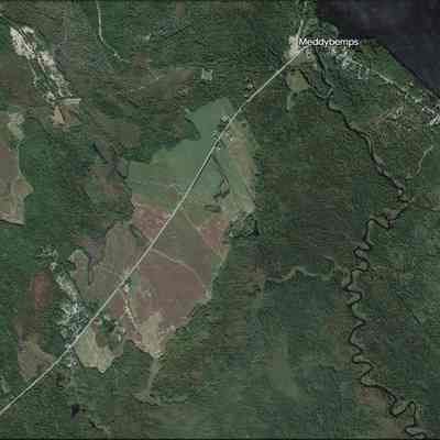 Meddybemps, Maine, on Google Earth, 2023: Eastern Surplus salvage yard is visible on the lower left corner of this detail from Google Earth in 2023.  For many years the government surplus materials collected here has been an invaluable source of scrap metal and parts for local residents, as well as  environmentalists concerned about contamination of the Dennys River, see to the right of the image.