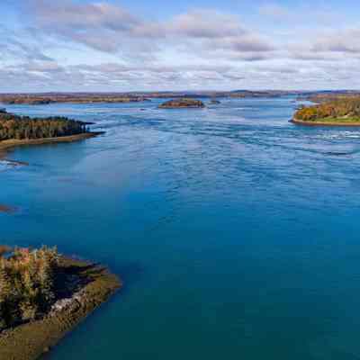 The Reversing Falls and Dennys Bay: Aerial view of the reversing looking west into Dennys Bay, with Falls Island on the left, and Mahar's Point on the end of Leighton's Neck on the right.  Photo by Chris Scott, courtesy of Cobscook Shores.