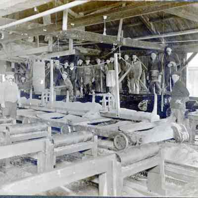 Interior of the Rotary Mill on the Dennys River: Millmen pose inside one of the two sawmills on the dam over the Dennys River in Dennysville, Maine.