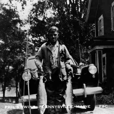 Phil Mahar with two Salmon: Phil Mahar with two freshly caught salmon in front of the Vose House, then owned by the Mahar family, in Dennysville, Maine.