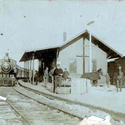 Dennysville Railroad Station: Passengers, horses and the Station Master await the arrival of the train at the Washington County Railroad Station in Dennysville, Maine, c. 1900.