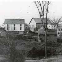          Shops and businesses on Store Hill in Dennysville, c. 1890.; Lyman K. Gardner's blacksmith shop occupies the center of this image on the banks of the Dennys River as seen from the Edmunds side of the river.
   