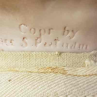 The image shows a close-up view of a textured surface with the embossed text "Copyr by Grace S. Putnam," which is surrounded by slightly worn fabric with frayed edges.